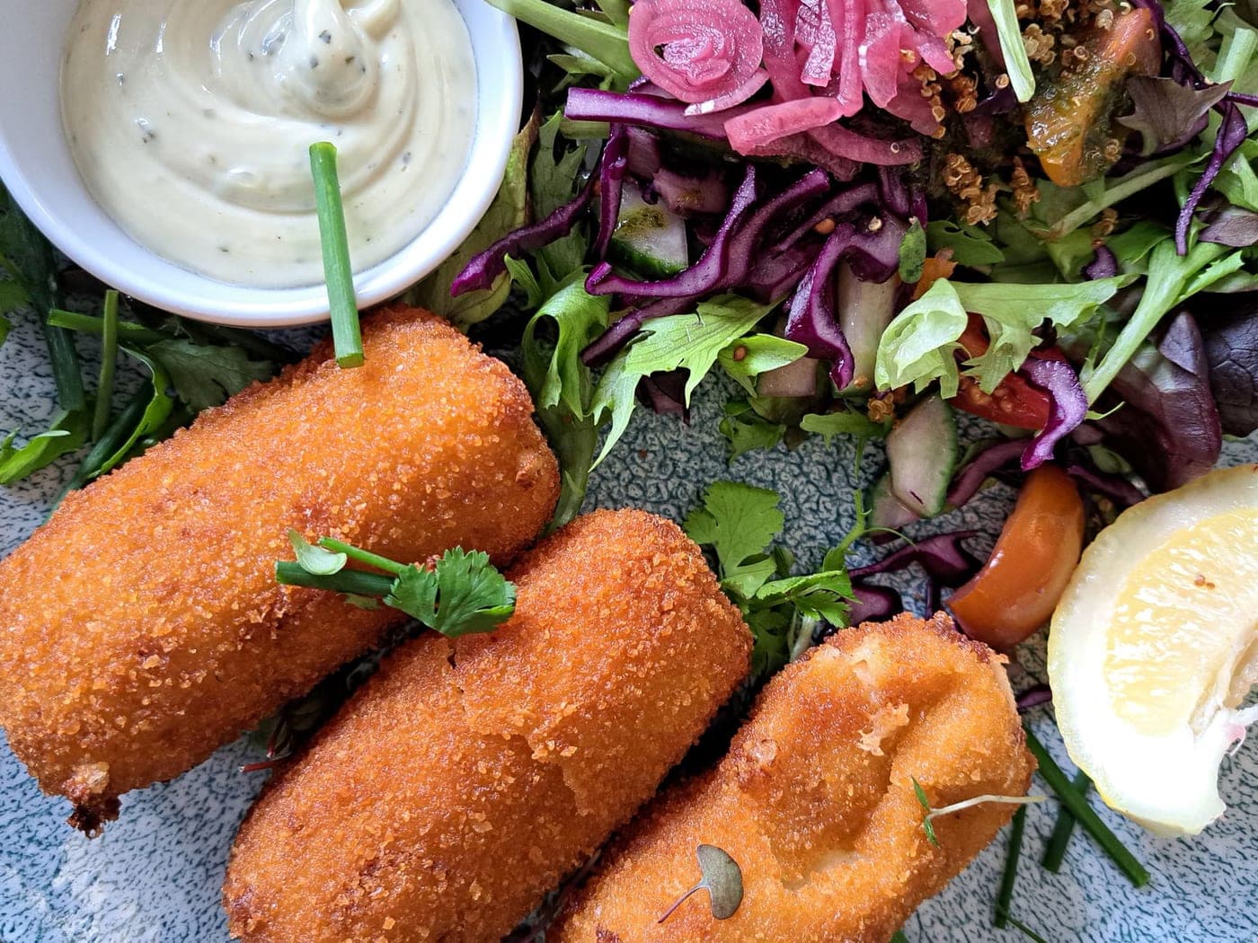 Croquettes de poisson maison, salade croquante et sauce citronnée