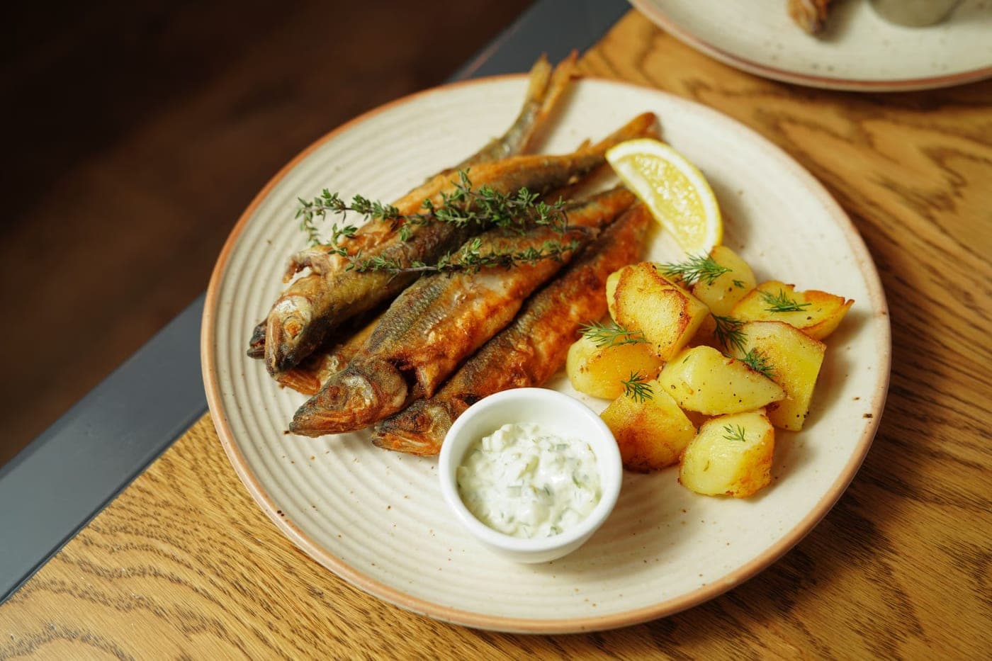 Poisson croustillant au four, pommes de terre rôties et sauce citronnée