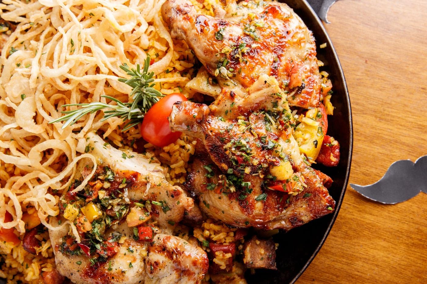 Poulet grillé sur riz aux herbes, oignons frits et tomates